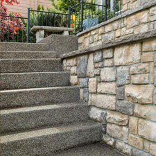 Freshly paved steps next to a beautiful stone exterior wall